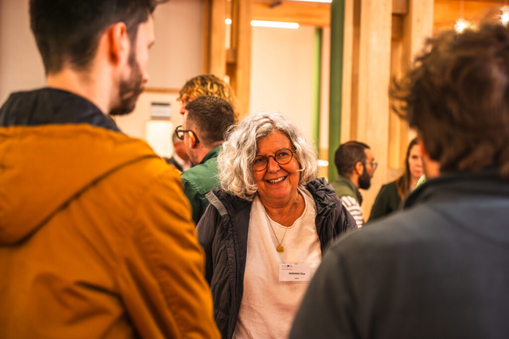 Participante souriante échangeant avec d'autres invités lors du temps informel.