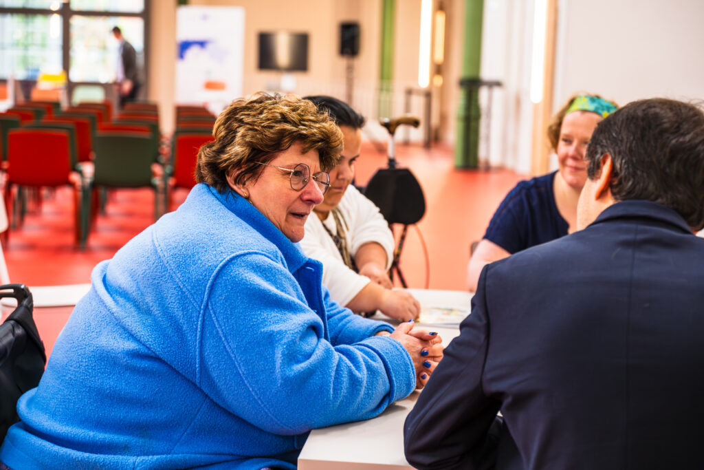Plusieurs personnes assises autour d'une table en pleine discussion collaborative.