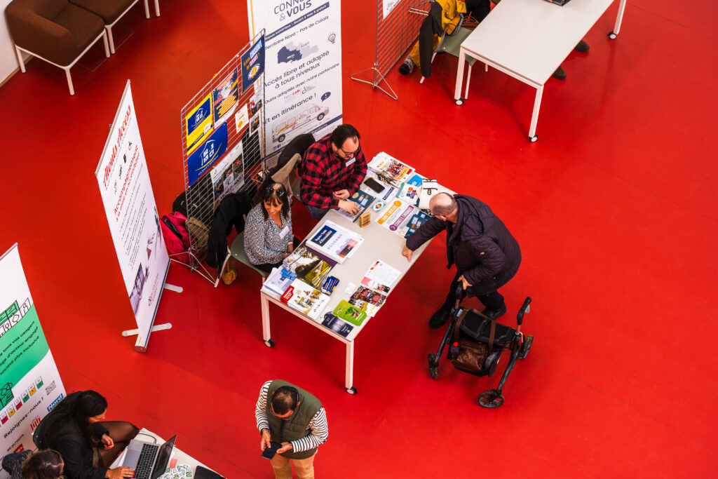 Participants réunis autour des tables d'information et des kakémonos du projet.