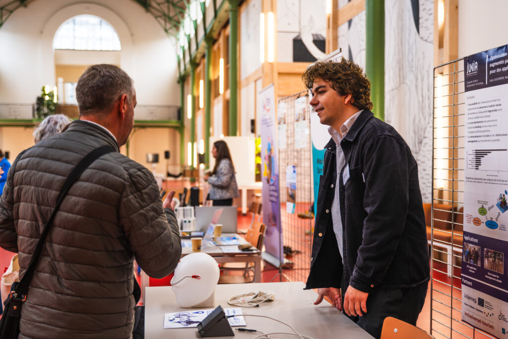 Un chercheur de JUNIA présente un poster scientifique sur les technologies de l'IA à un participant.
