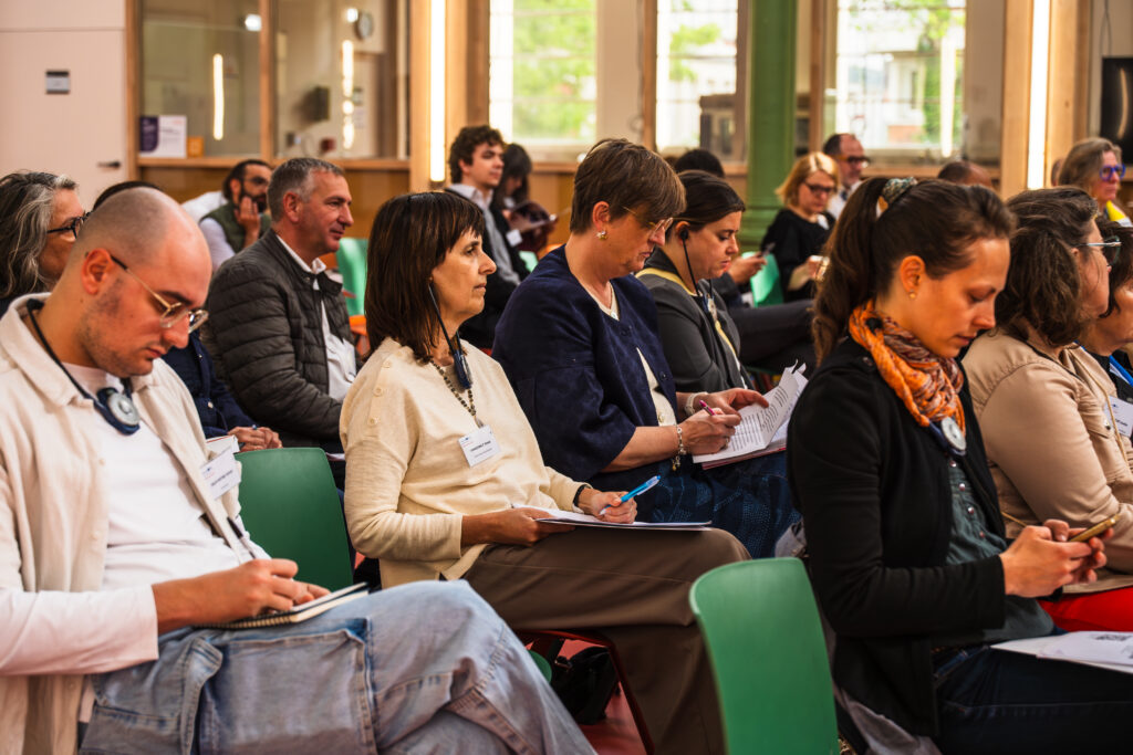 Rangée de participants très attentifs prenant des notes dans leur carnet.